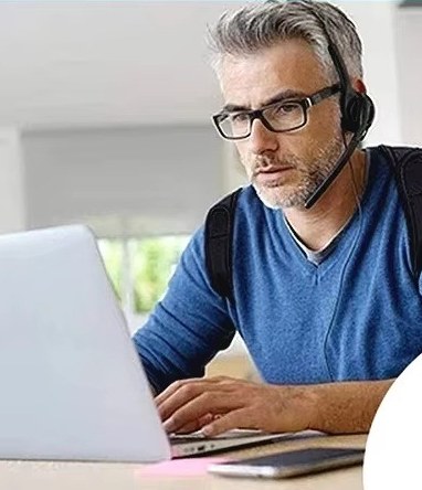 גבר יושב מול מחשב נייד כשהוא חובש את חגורת היציבה